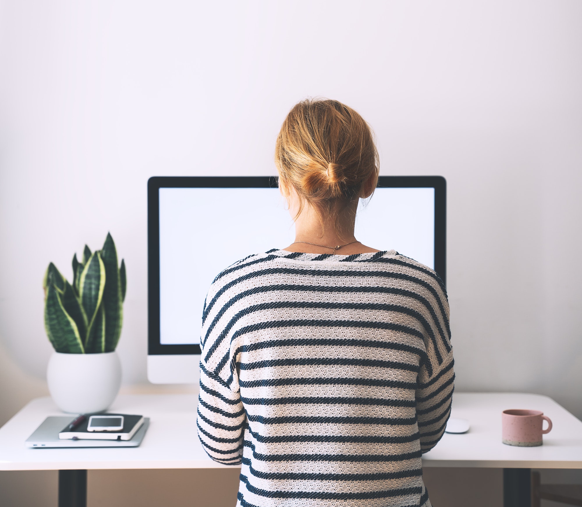 Woman working on computer at home office.